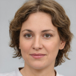 Joyful white young-adult female with medium  brown hair and green eyes