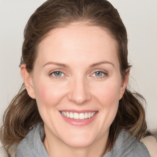 Joyful white young-adult female with medium  brown hair and grey eyes