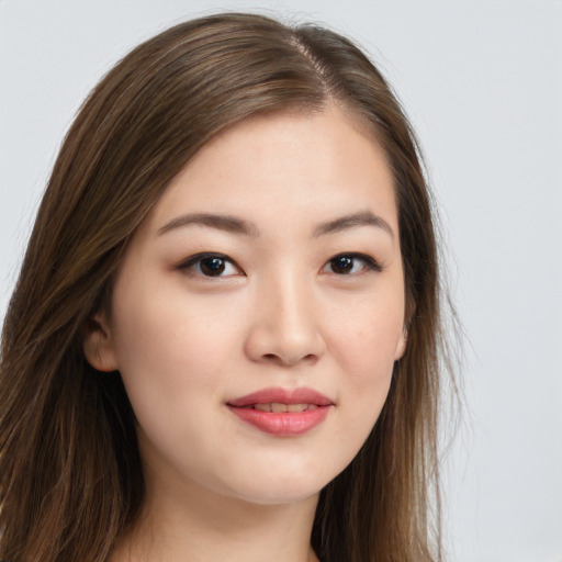 Joyful asian young-adult female with long  brown hair and brown eyes