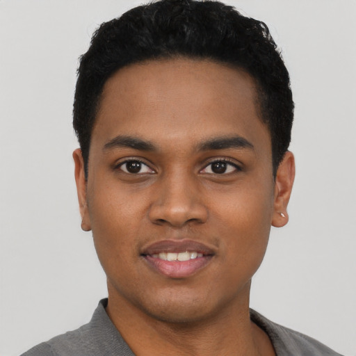 Joyful black young-adult male with short  black hair and brown eyes