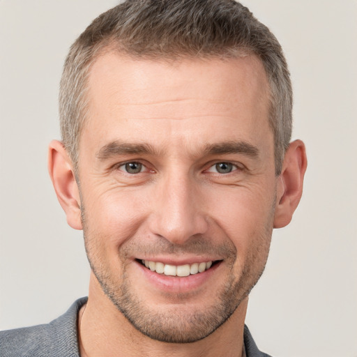 Joyful white adult male with short  brown hair and brown eyes