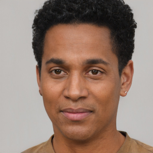 Joyful black young-adult male with short  black hair and brown eyes