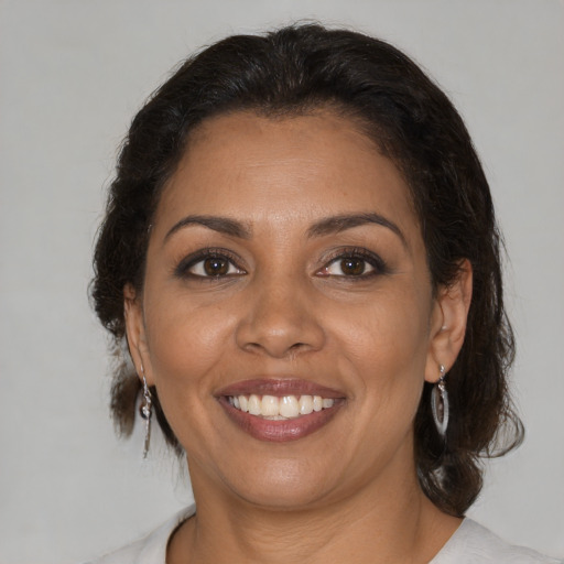 Joyful latino young-adult female with medium  brown hair and brown eyes