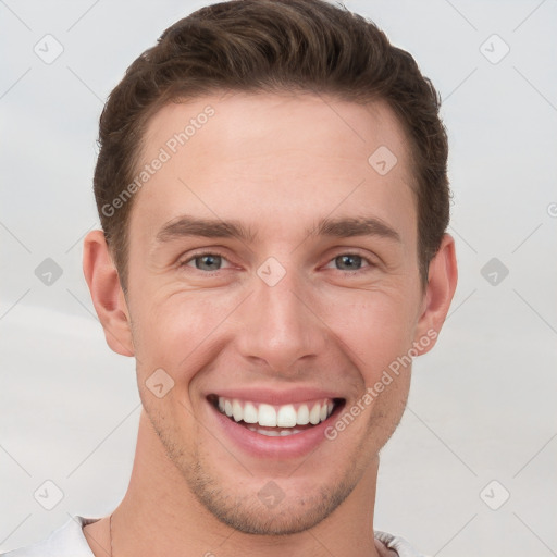 Joyful white young-adult male with short  brown hair and grey eyes