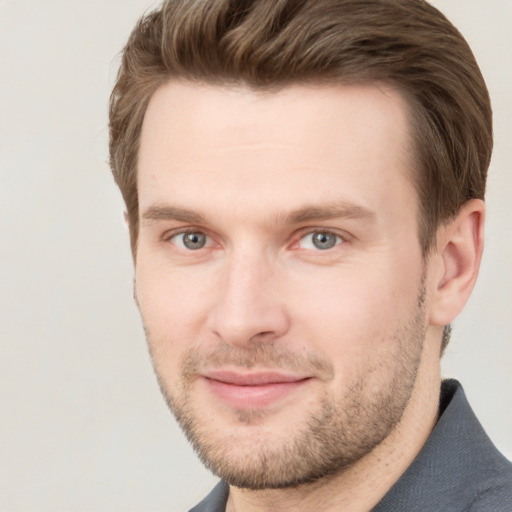 Joyful white young-adult male with short  brown hair and grey eyes