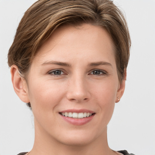 Joyful white young-adult female with short  brown hair and grey eyes