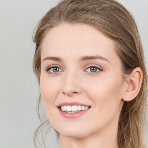 Joyful white young-adult female with long  brown hair and blue eyes