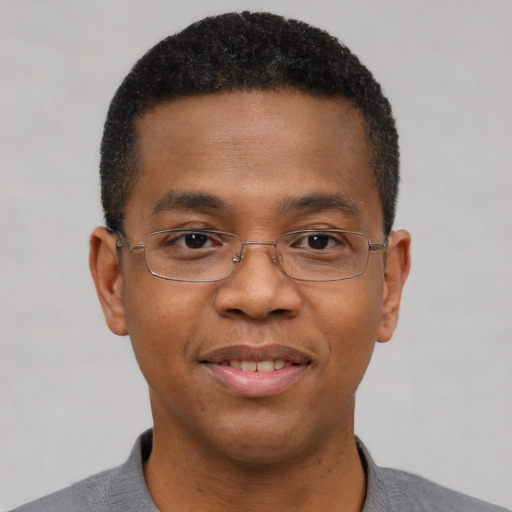 Joyful black adult male with short  black hair and brown eyes