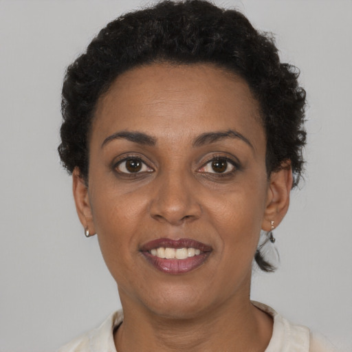 Joyful black adult female with short  brown hair and brown eyes