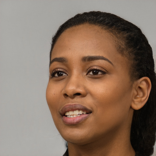 Joyful black young-adult female with long  black hair and brown eyes