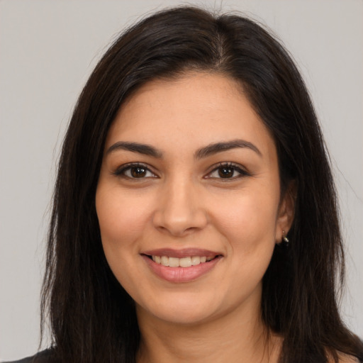 Joyful latino young-adult female with long  brown hair and brown eyes