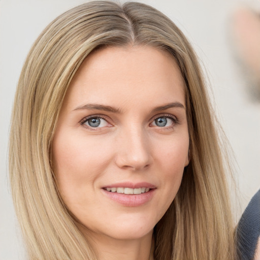 Joyful white young-adult female with long  brown hair and blue eyes