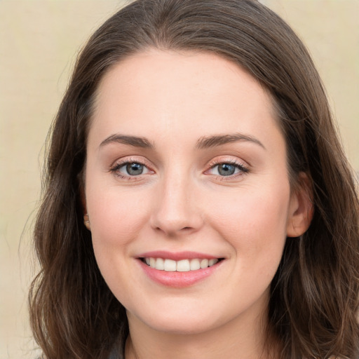 Joyful white young-adult female with long  brown hair and grey eyes