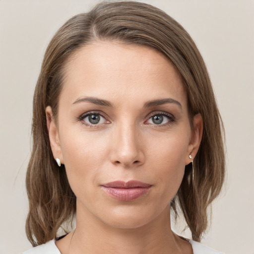 Joyful white young-adult female with medium  brown hair and grey eyes