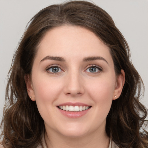 Joyful white young-adult female with long  brown hair and blue eyes