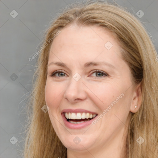 Joyful white adult female with long  brown hair and blue eyes