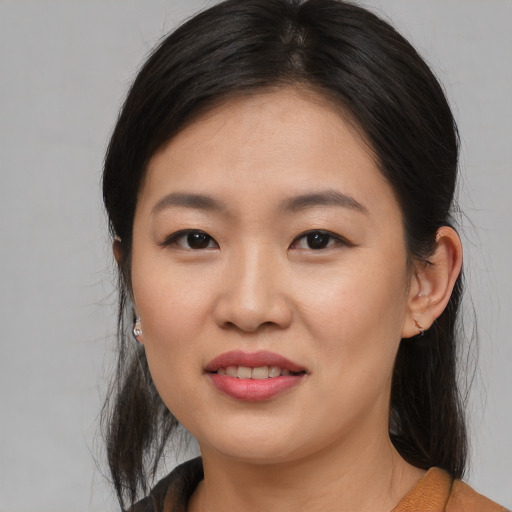 Joyful asian young-adult female with medium  brown hair and brown eyes