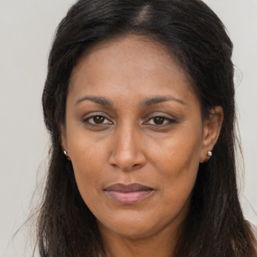 Joyful latino adult female with long  brown hair and brown eyes