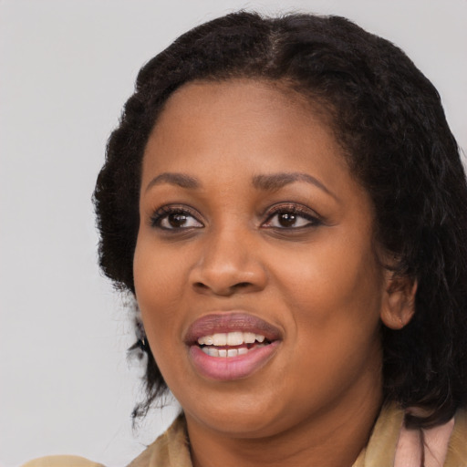 Joyful black adult female with long  black hair and brown eyes
