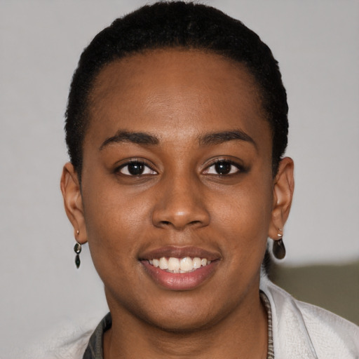 Joyful black young-adult female with short  brown hair and brown eyes