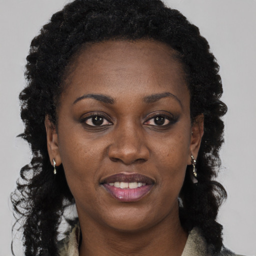 Joyful black young-adult female with long  brown hair and brown eyes