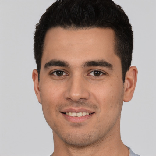 Joyful white young-adult male with short  black hair and brown eyes