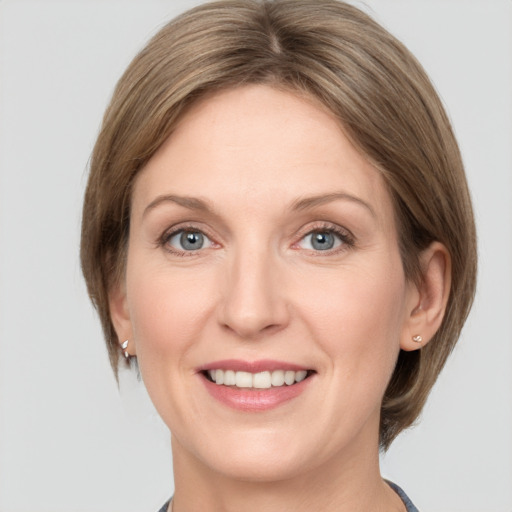 Joyful white adult female with medium  brown hair and grey eyes