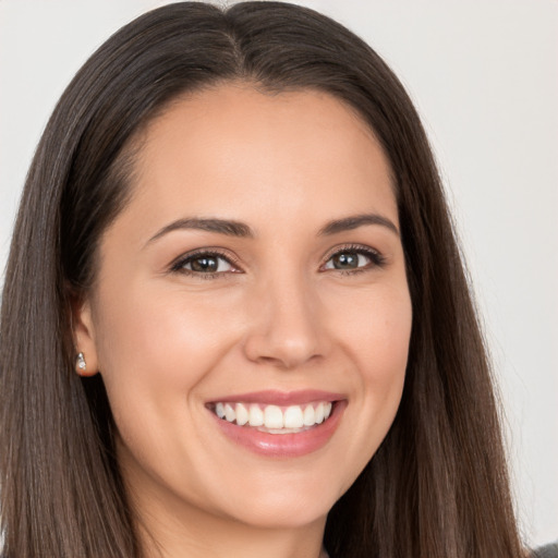 Joyful white young-adult female with long  brown hair and brown eyes