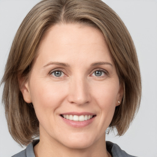 Joyful white adult female with medium  brown hair and grey eyes