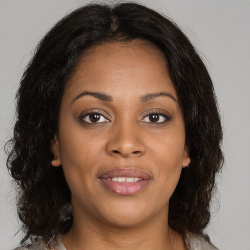 Joyful black young-adult female with medium  brown hair and brown eyes