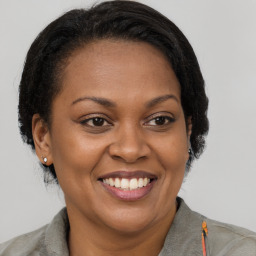 Joyful black adult female with short  brown hair and brown eyes