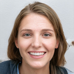 Joyful white young-adult female with long  brown hair and blue eyes