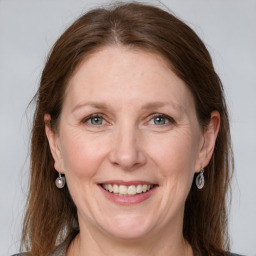 Joyful white adult female with long  brown hair and grey eyes