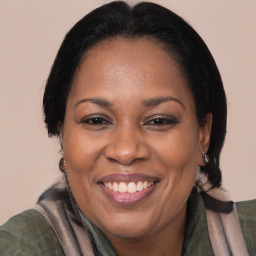 Joyful black adult female with long  brown hair and brown eyes