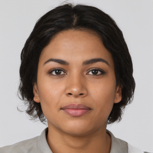 Joyful latino young-adult female with medium  brown hair and brown eyes