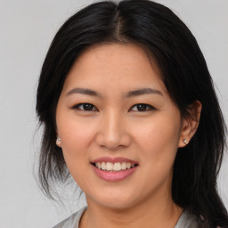 Joyful asian young-adult female with long  brown hair and brown eyes