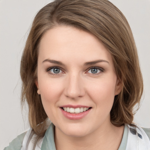 Joyful white young-adult female with medium  brown hair and green eyes