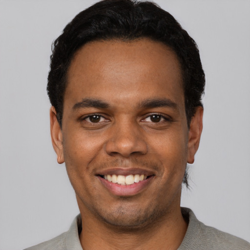 Joyful latino young-adult male with short  black hair and brown eyes