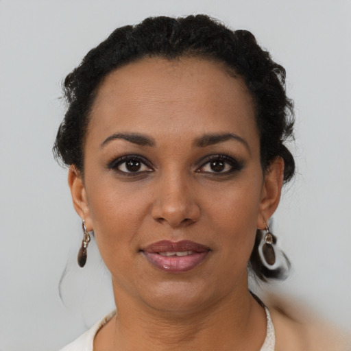 Joyful black young-adult female with short  brown hair and brown eyes