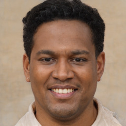 Joyful latino young-adult male with short  black hair and brown eyes