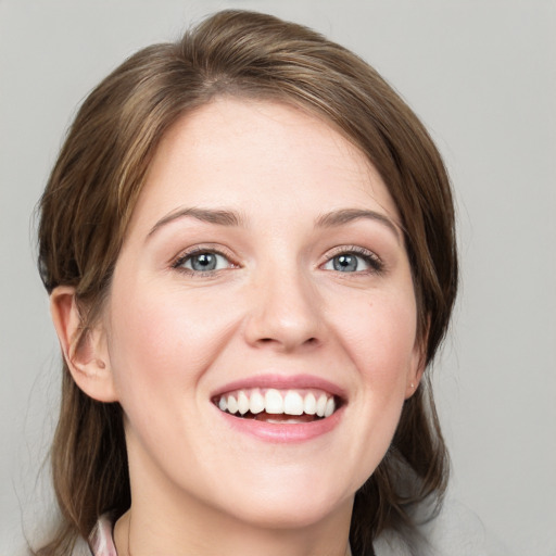 Joyful white young-adult female with medium  brown hair and blue eyes