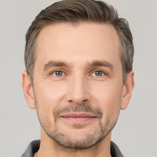 Joyful white adult male with short  brown hair and brown eyes