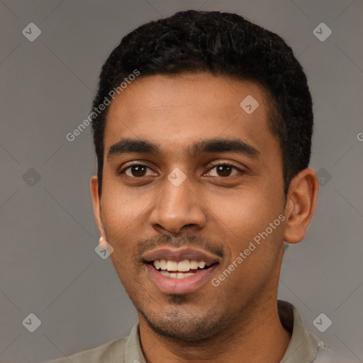 Joyful black young-adult male with short  black hair and brown eyes