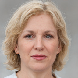 Joyful white adult female with medium  brown hair and blue eyes