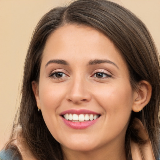 Joyful white young-adult female with long  brown hair and brown eyes