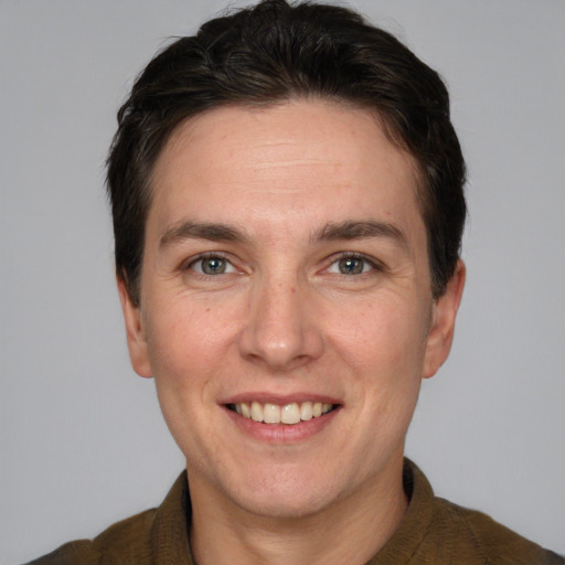 Joyful white adult male with short  brown hair and grey eyes