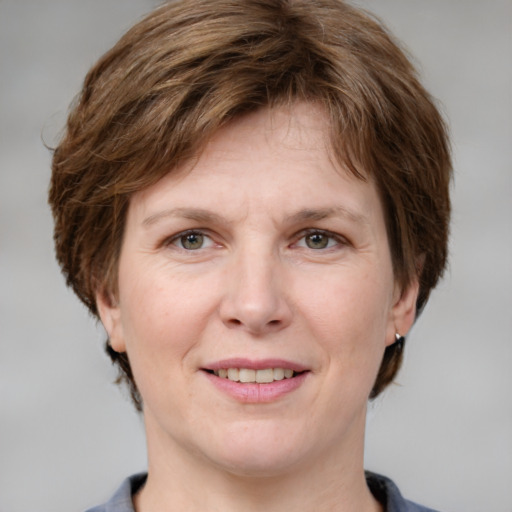 Joyful white adult female with medium  brown hair and grey eyes