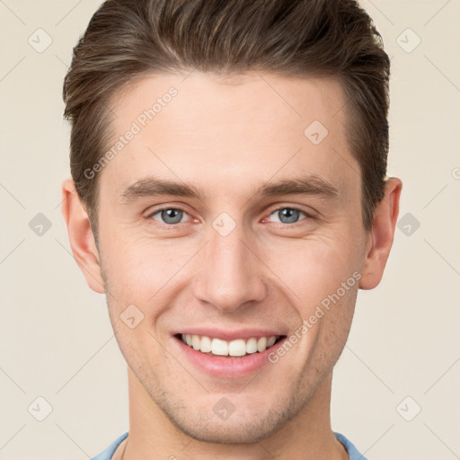 Joyful white young-adult male with short  brown hair and grey eyes