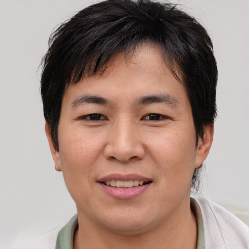 Joyful asian young-adult male with short  brown hair and brown eyes