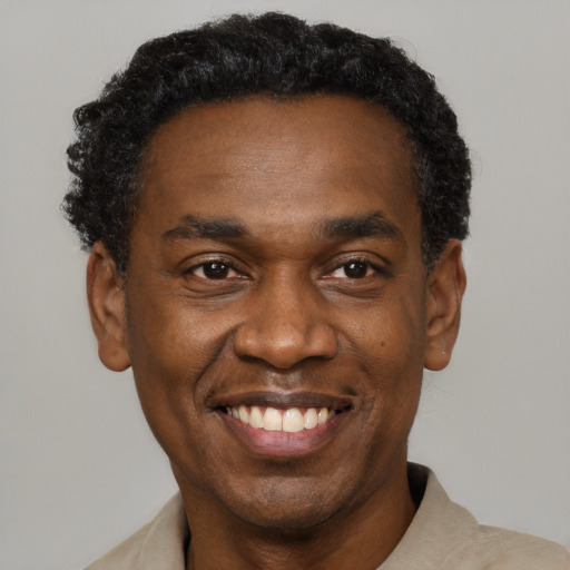 Joyful black adult male with short  black hair and brown eyes